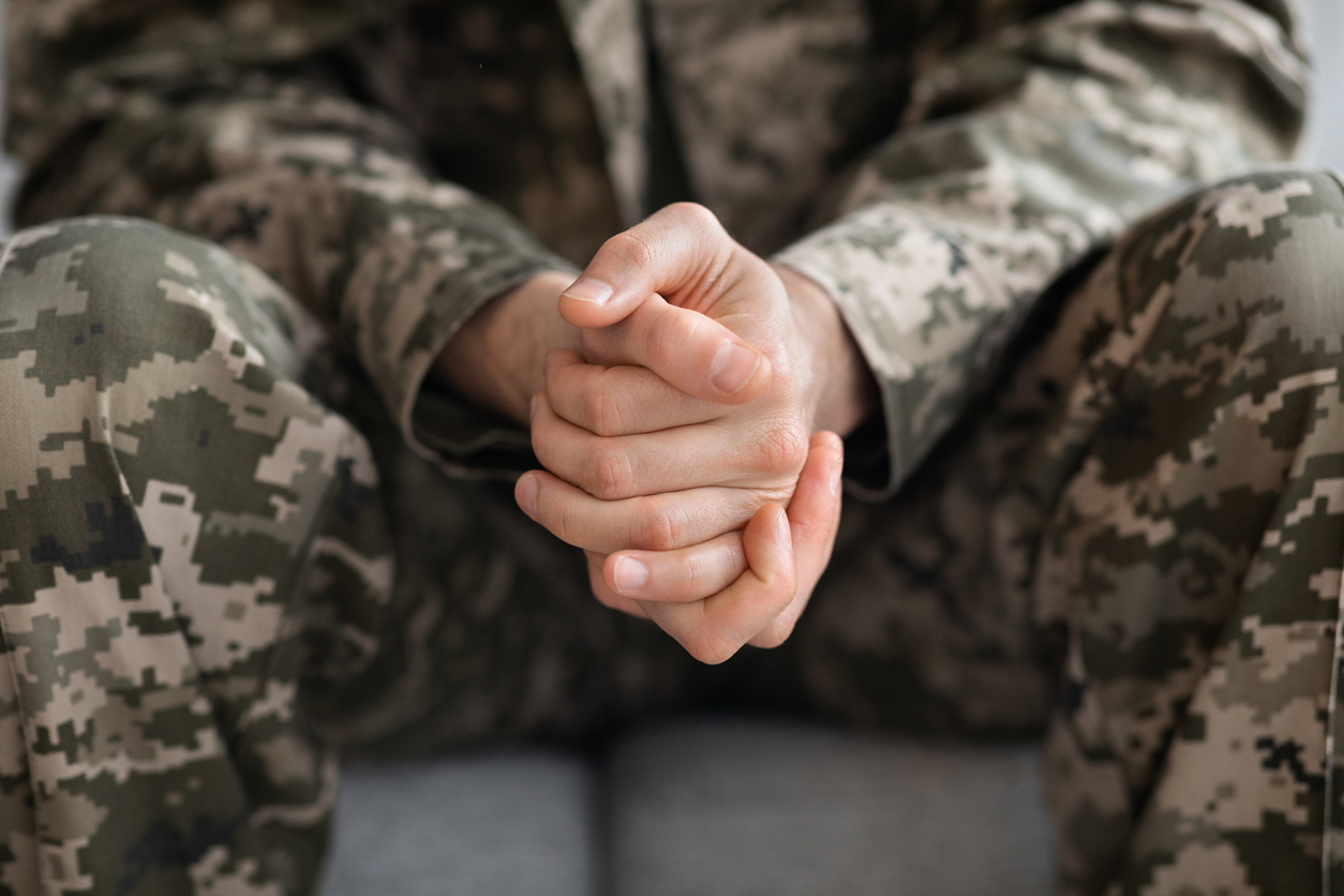 Cropped of soldier sitting on couch alone Defensie