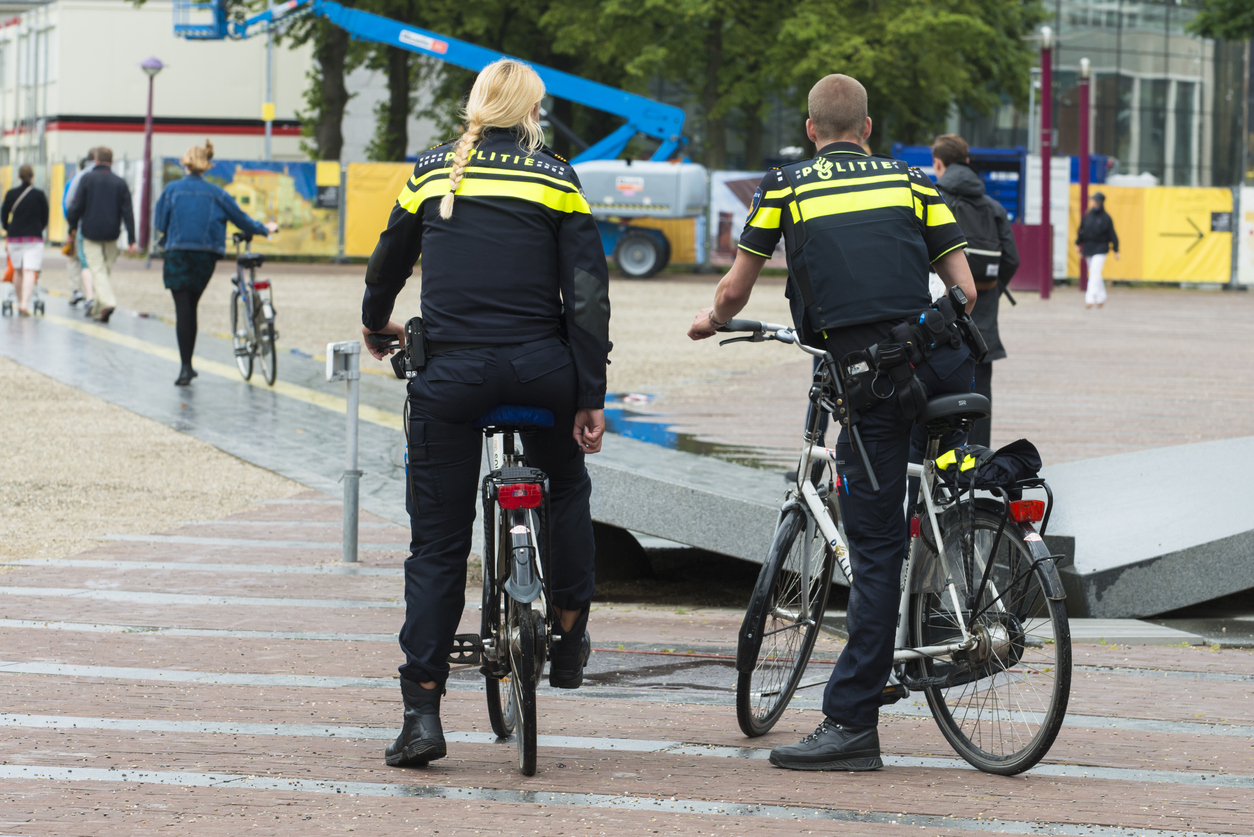 A couple of cops, mounted on bicycles. Politie. Twee politiemensen op een fiets